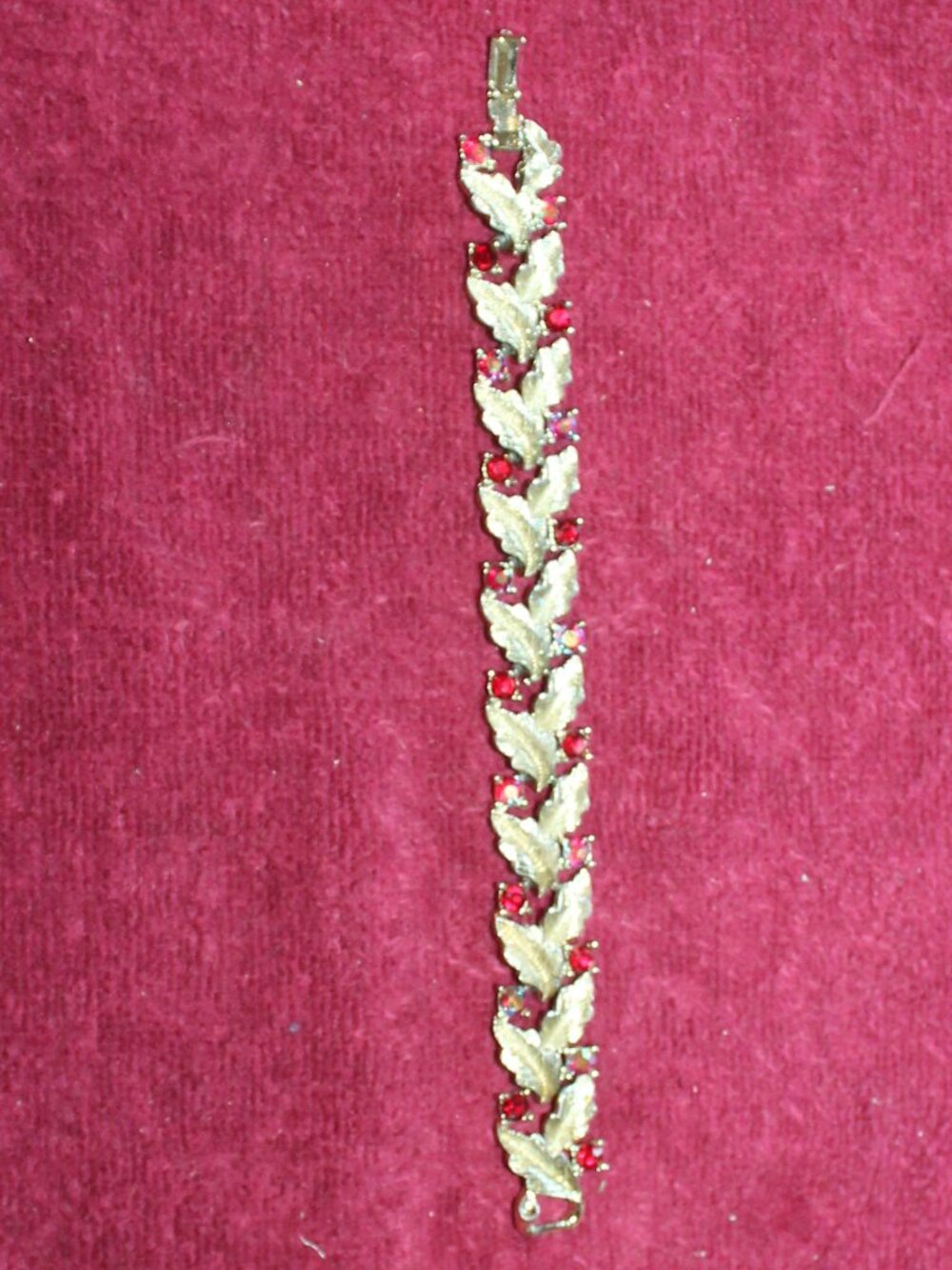 Coro vintage bracelet features a gold-tone leaf design adorned w/red rhinestones